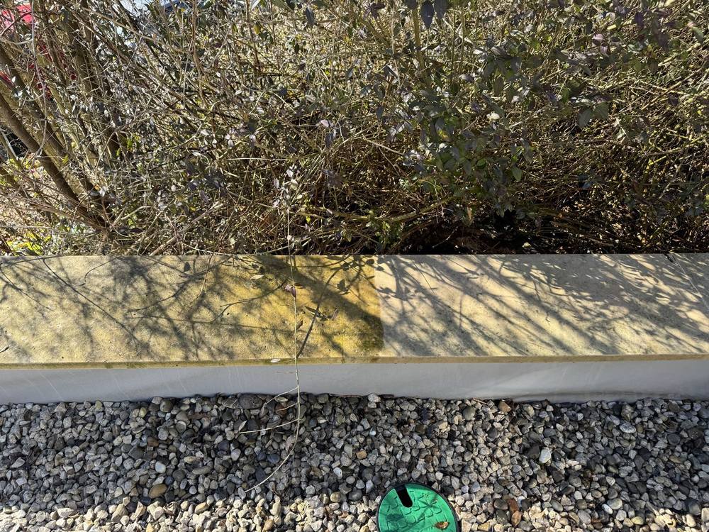 Bordstein, links verschmutzt, rechts nach der Reinigung mit Kärcher